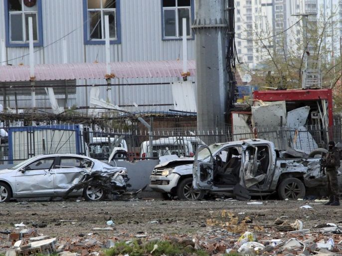 A member of the police special forces stands next to vehicles, which were damaged by a car bomb attack that targeted a minibus (not pictured) carrying members of the police special forces, occurred in the Kurdish-dominated southeastern city of Diyarbakir, Turkey March 31, 2016. REUTERS/Stringer FOR EDITORIAL USE ONLY. NO RESALES. NO ARCHIVE.