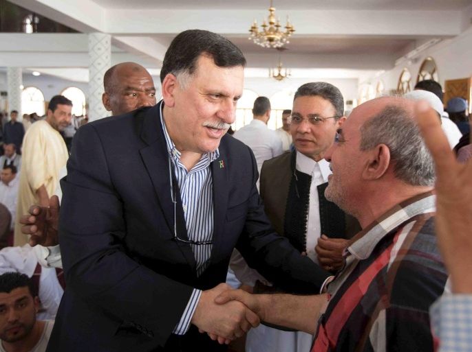 Unity government head Fayez Seraj (L) shakes hands with a man inside a mosque after Friday prayers, during a tour in Tripoli city, Libya, April 1, 2016, in this handout photo provided by the Office of Information. REUTERS/Office of Information/Handout via Reuters ATTENTION EDITORS - THIS IMAGE HAS BEEN SUPPLIED BY A THIRD PARTY. IT IS DISTRIBUTED, EXACTLY AS RECEIVED BY REUTERS, AS A SERVICE TO CLIENTS. FOR EDITORIAL USE ONLY. NOT FOR SALE FOR MARKETING OR ADVERTISING CAMPAIGNS.