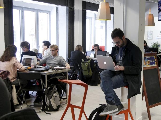 Entrepreneurs work at their computer laptops at the so-called "incubator" of French high-tech start-ups "Numa" in Paris, France, in this March 11, 2016 file photo. REUTERS/Charles Platiau/Files