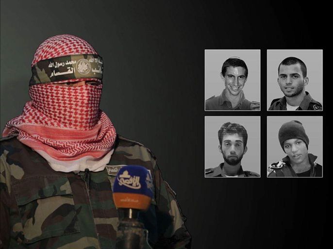 الناطق باسم كتائب القسام يظهر خلال تصريح لفضائية الأقصى وخلفه صور للجنود الإسرائيليين في غزة