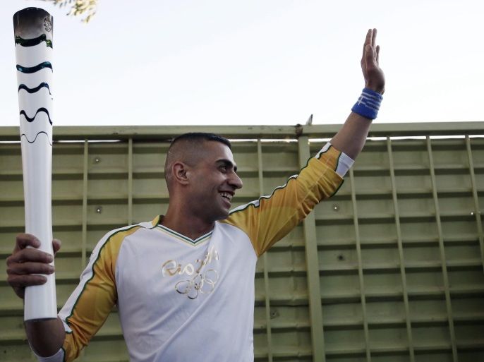 Syrian disabled swimmer, granted asylum in Greece, Ibrahim Al-Hussein holds the Olympic torch, during the Olympic torch relay at the refugee camp of Eleonas in Athens, Greece, 26 April 2016. In 2014, Ibrahim al-Hussein crossed the Aegean from Turkey to Greece on a rubber boat, after having lost part of his right leg during a bombing in Syria, according to the UNHCR. The Summer Olympic Games will be held in Rio de Janeiro, Brazil from 03 August to 21 August 2016.