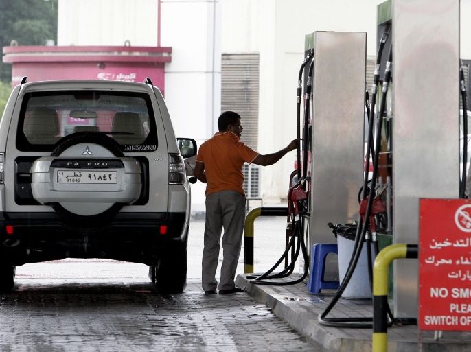 In this Saturday, Dec. 1, 2012 photo, a man fills his car with gasoline at a gas station in Doha, Qatar. The host of the current U.N. climate talks, Qatar, is among dozens of nations that keep gas prices low through subsidies that exceeded $500 billion globally last year. (AP Photo/Osama Faisal)