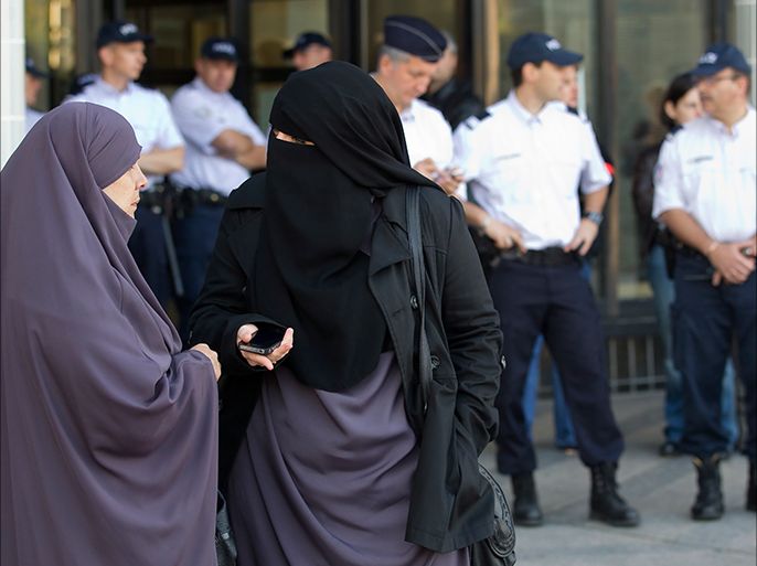 epa02929333 Women wearing niqabs converse as police stand watch in front of the courthouse in Meaux, near Paris, France, 22 September 2011. The Meaux court, on 22 September, convicted two women for wearing Islamic veils in public - the first conviction since a ban on wearing the veils came into effect in April. The court in the town of Meaux, about 40 kilometres east of Paris, fined Hind Ahmas, 32, and another woman for appearing outside the local town hall in niqabs - a veil that covers the hair and face leaving a slit for the eyes, their lawyer Gilles Devers told the German Press Agency dpa. Devers said Ahmas was fined 120 euros and the other woman 80 euros. EPA/IAN LANGSDON