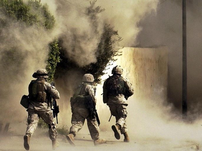 FILE - In this Oct. 26, 2004 file photo, U.S. Marines from the 2nd Battalion, 5th Marine Regiment, run to a building after detonating explosives to open a gate during a mission in Ramadi in Anbar province, Iraq. U.S. President Barack Obama said Friday, Nov. 7, 2014, that he authorized the deployment of up to 1,500 more American troops to bolster Iraqi forces. For the first time since the U.S. withdrawal in December 2011, American military personnel will be on the ground in Iraq’s historically dangerous Anbar province, helping train the Iraqi military for its fight against the Islamic State group. Anbar resonates with many Americans because they recall how costly the fighting was there for U.S. troops. More than 3,500 U.S. soldiers died in combat in Iraq between 2003 and 2011 - and there are concerns that sending Americans back to Anbar in any capacity will inevitably make them a target. (AP Photo/Jim MacMillan, File)