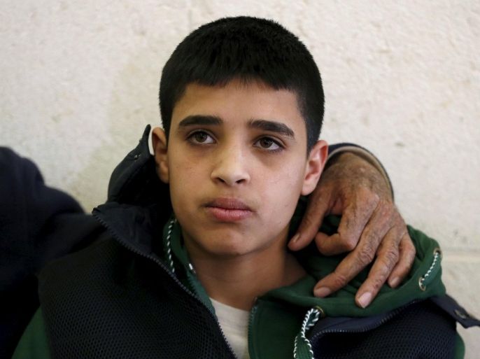 Ahmed Manasra, a 13-year-old Palestinian, waits before a court session at the District Court in Jerusalem January 19, 2016. Israeli police have accused Manasra, together with his 15-year-old cousin, of attacking a 13-year-old Israeli boy on October 12, 2015 in Pisgat Zeev, built on occupied land that Israel annexed to Jerusalem after the 1967 war. The family has denied Manasra did it. REUTERS/Ammar Awad