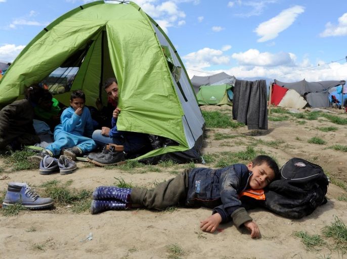 A boy sleeps outside a tent at a makeshift camp for refugees and migrants at the Greek-Macedonian border near the village of Idomeni, Greece, May 5, 2016. REUTERS/Alexandros Avramidis