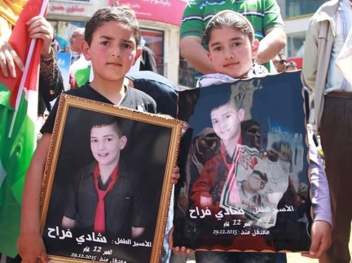 فلسطين القدس نيسان 2016 شقيقا الطفل الأسير شادي فراج يحملان صورته خلال اعتصام تضامني مع الأسرى