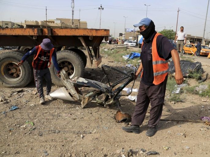 Municipality workers clean up debris a day after a car bomb explosion in Baghdad, Iraq, Thursday, May 12, 2016. In the deadliest violence in Baghdad this year, three car bombs claimed by the Islamic State group killed and wounded dozens of civilians across the Iraqi capital Wednesday, demonstrating the extremists' ability to mount significant attacks despite major battlefield losses. (AP Photo/Karim Kadim)