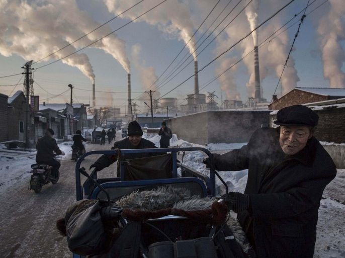 Daily Life, 1st prize singles, World Press Photo Awards (Kevin Frayer - China's Coal Addiction)Chinese men pull a tricycle in a neighborhood next to a coal-fired power plant in Shanxi, China, November 26, 2015. A history of heavy dependence on burning coal for energy has made China the source of nearly a third of the world's total carbon dioxide (CO2) emissions, the toxic pollutants widely cited by scientists and environmentalists as the primary cause of global warmin