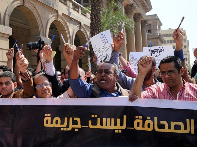 epa05281309 Egyptian journalists hold up pens and banner reading in Arabic 'journalism is not a crime' during a protest outside the Egyptian Press Syndicate in downtown Cairo, Egypt, 28 April 2016.