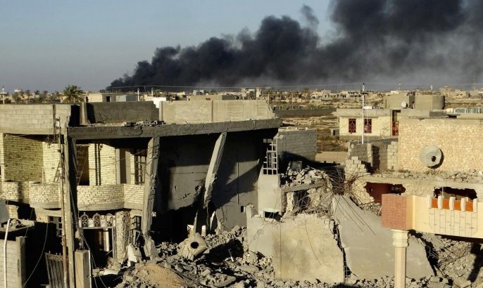 FILE - Smoke rises from Islamic State group positions after an airstrike by U.S.-led coalition warplanes in the Iraqi city of Ramadi in this Dec. 25, 2015 file photo during the Iraqi government offensive that drove the militants out of the city. Ramadi, the provincial capital of Iraq’s Sunni heartland, was declared “fully liberated” early this year. But the cost of victory may have been the city itself, with widespread destruction from strikes, artillery and the militants' scorched earth tactic of destroying buildings and infrastructure as they fled. (AP Photo, File)