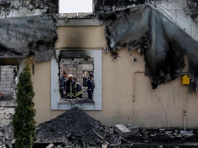 Firefighters work in a burned residential building housing elderly people after a fire broke out, in the village Litochky near Kiev, Ukraine, May 29, 2016. REUTERS/Gleb Garanich