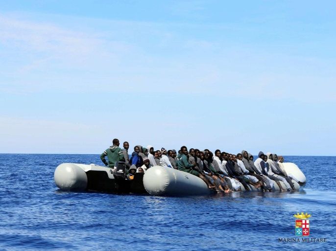 Migrants sit in their boat during a rescue operation by Italian navy ship Grecale (unseen) off the coast of Sicily, Italy, in this handout picture courtesy of the Italian Marina Militare released on May 6 2016. Marina Militare/Handout via REUTERS ATTENTION EDITORS - THIS PICTURE WAS PROVIDED BY A THIRD PARTY. FOR EDITORIAL USE ONLY.