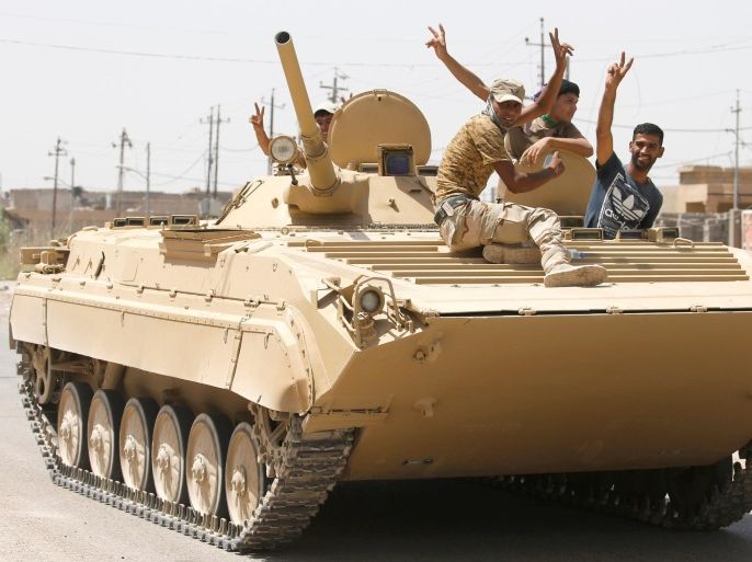 Iraqi soldiers gesture from a top of a tank in Falluja, Iraq, June 23, 2016. REUTERS/Thaier Al-Sudani