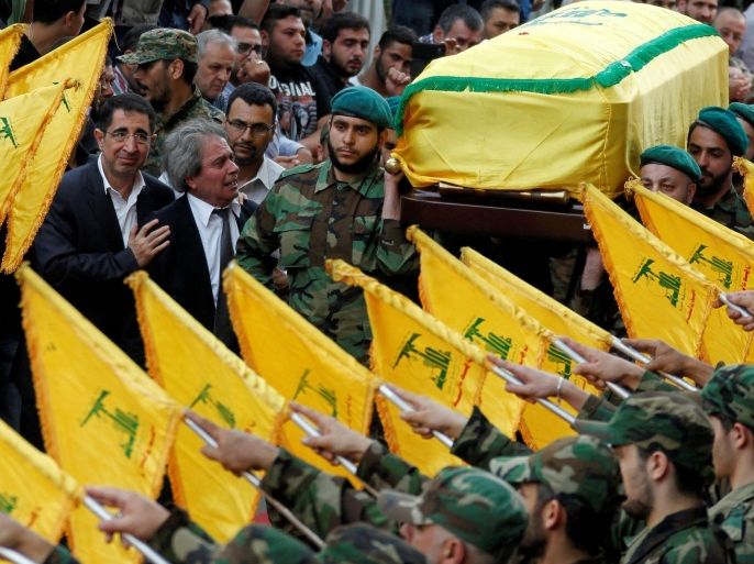 Hezbollah Industry Minister Hussein Hajj Hassan (L) comforts the brother of top Hezbollah commander Mustafa Badreddine, who was killed in an attack in Syria, as Hezbollah members carry his coffin during his funeral in Beirut's southern suburbs, Lebanon, May 13, 2016. REUTERS/Aziz Taher