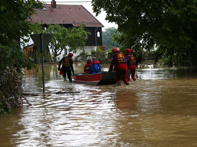 A rescue team moves a boat in the flooded street in the Bavarian village of Triftern east of Munich, Germany, June 1, 2016. REUTERS/Michaela Rehle