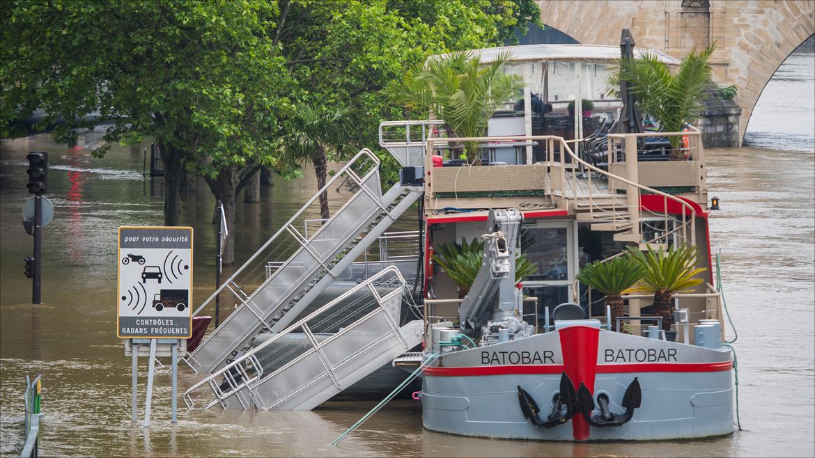 epa05340820 A view of the Seine river from Saint Louis Island, shows a partially submerged restaurant boat, in Paris, France, 01 June 2016. Heavy rains hit a quarter of the French territory over several days causing floods.  EPA/CHRISTOPHE PETIT TESSON