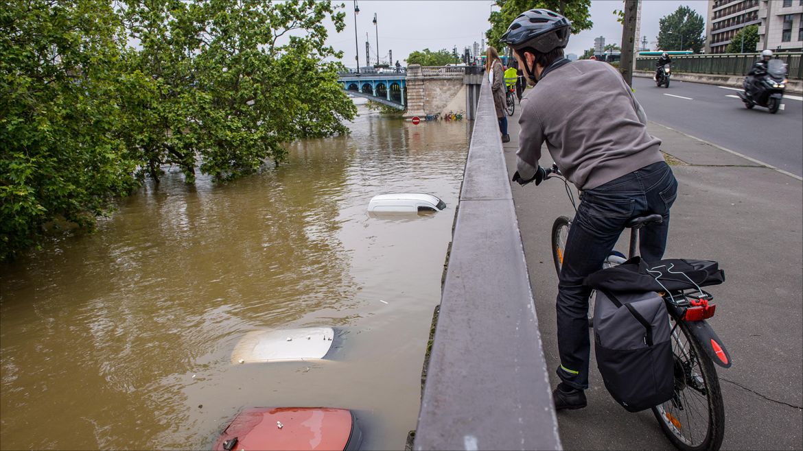 epa05342732 A man takes a look on the Seine river and three submerged cars on a car park under  the Asnieres bridge due to heavy rains in Asnieres, northern suburb of Paris, France, on 02 June 2016. Floods and heavy rain drenched about a quarter of the French territory over several days.  EPA/CHRISTOPHE PETIT TESSON