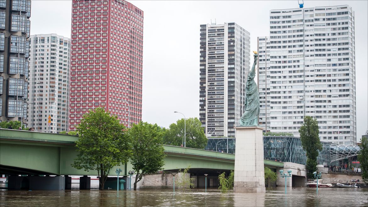 epa05344094 The replica of the Statue of Liberty (C) is partially submerged by the flooding of the Seine river in Paris, France, 03 June 2016. Floods and heavy rain drenched about a quarter of the French territory over several days.  EPA/JEREMY LEMPIN