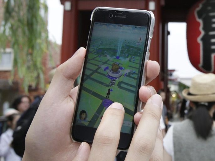 A Japanese Pokemon fan plays the newly released Pokemon Go hit-mobile game by Japanese videogame company Nintendo in front of Kaminarimon, the socalled Thunder Gate of the Buddhist Senso-ji temple, in Tokyo's downtown Asakura district, Japan, 22 July 2016. The game which was released in Japan on 22 July and uses GPS to locate the smartphone's position, has gained a huge popularity among smartphone users and added to the value of Nintendo that partly owns the franchise enterprise that makes Pokemon. Japanese government has issued a warning to use this game. Nintendo stock share continues to rise with McDonald Japan after the releasement.