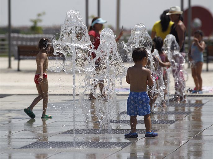 epa05405272 Children play in a fountain in a park in Madrid, Spain, 03 July 2016. Authorities issued a yellow alert for hot weather in Madrid as temperatures could reach 38 Celsius degrees. EPA/JAVIER LIZON
