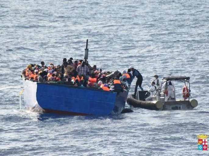 Migrants sit in their boat during a rescue operation by Italian navy ship Borsini (unseen) off the coast of Sicily, Italy, in this handout picture courtesy of the Italian Marina Militare released July 19, 2016. Marina Militare/Handout via REUTERS ATTENTION EDITORS - THIS PICTURE WAS PROVIDED BY A THIRD PARTY. FOR EDITORIAL USE ONLY. NO RESALES. NO ARCHIVES.