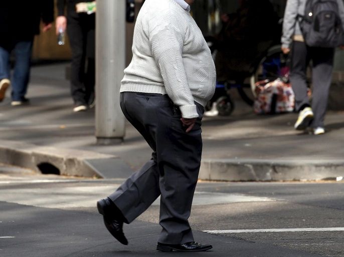 A man crosses a main road as pedestrians carrying food walk along the footpath in central Sydney, Australia, August 12, 2015. Fast food may be falling out of favour in many countries around the world but companies are making healthy profits and boldly innovating in the unlikely market of Australia. Contrary to stereotypes of a beach-going community of fitness fanatics, official data out this week showed 40 percent of Australian adults are dangerously obese and have a poor diet that includes lashings of fast food. That makes Australia a hotbed for innovation by companies including homegrown firm Domino's Pizza Enterprises Ltd, McDonald's Corp and Yum! Brands Inc's, KFC and Pizza Hut as they struggle to win over health-conscious diners in other countries. Picture taken August 12, 2015. REUTERS/David Gray
