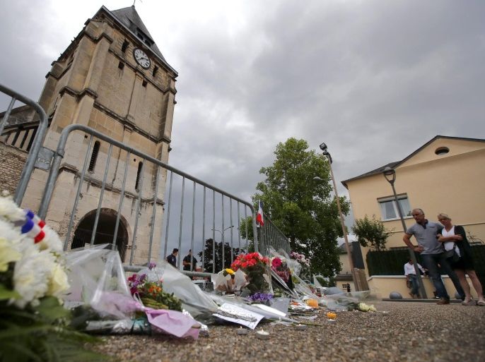 People pay tribute at a makeshift memorial near the Saint Etienne church, where priest Jacques Hamel was killed, in Saint-Etienne-du-Rouvray, near Rouen, France, 27 July 2016. According to reports, two hostage takers were killed by the police after they took hostages at a church in Saint-Etienne-du-Rouvray. One of the hostages, a priest was killed by one of the perpetrators.