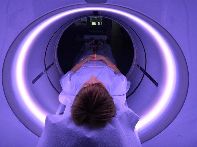 An x-ray assistant lies in a CT scanner for purposes of demonstration in the emergency room of the University Hospital (UKJ) in Jena, Germany, 20 January 2016. The UKJ is the first hospital in Germany to employ a new kind of CT scanner in the emergency room. Various steps of treatment can be performed through with a single scan, while simultaneously reducing radiation exposure for the patient. The GE Healthcare scanner is called the 'Revolution CT.' 