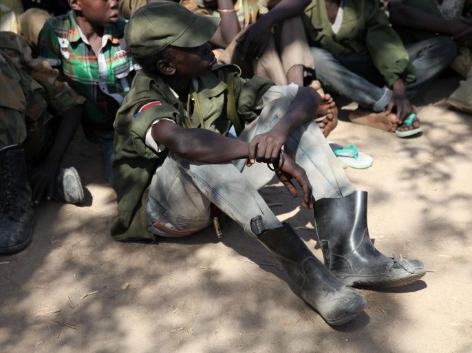 Rebel child soldiers gather in Gumuruk, as they prepare to handover their weapons at a demobilisation ceremony in Jonglei State, eastern South Sudan, January 27, 2015. The teenage rebel soldiers watched as their comrades handed over their assault rifles and stripped off their oversized khaki uniforms with the red, black and green South Sudan flag emblazoned on the right shoulder. Picture taken January 27, 2015. To match story SOUTHSUDAN-CHILD SOLDIERS/ REUTERS/Ka