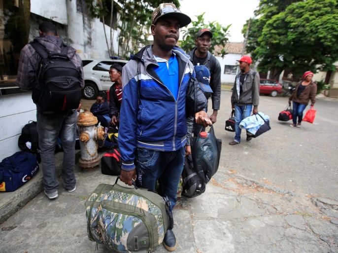 Haitian migrants carry their belongings while seeking to resolve their legal situation to avoid deportation from Colombia and continue their way to Panama and the United States, in Cali, Colombia, August 10, 2016. REUTERS/Jaime Saldarriaga