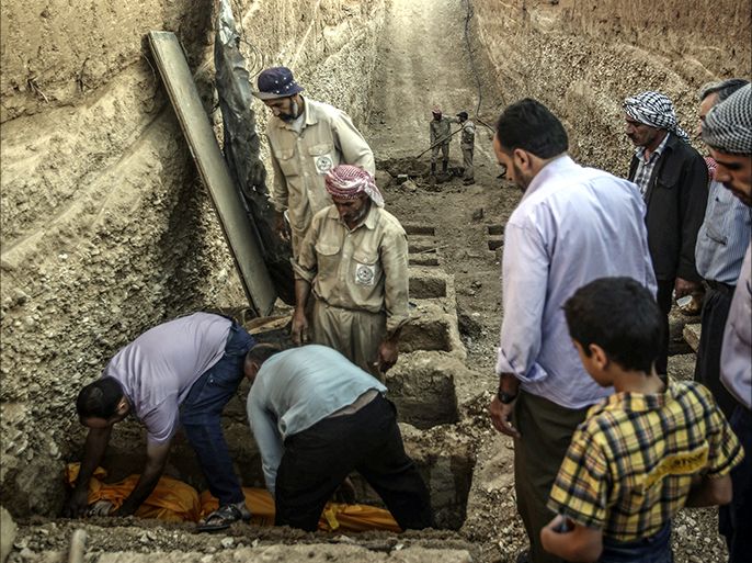 epaselect epa05496209 People observe as others lay down the body of a dead woman inside a grave in the multi-layered graveyard of Douma city, outskirts of Damascus, Syria, 18 August 2016. The Local Council of Douma started digging multi-layered graves as a solution for the massacre that happened in August of 2015 when more than 100 Syrian were killed in airstrikes on the Rebel-held city of Douma, 60 people were buried in two mass graves in that night. The graveyard always contains at least 40 empty graves in case of mass killing. The graves contains eight stairs, and is organized to bury the unknown on top in case they were identified later. EPA/MOHAMMED BADRA