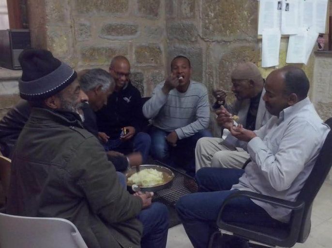 القدس- أفراد من الجالية الأفريقية بالقدس يتناولون وجبة العصيدة