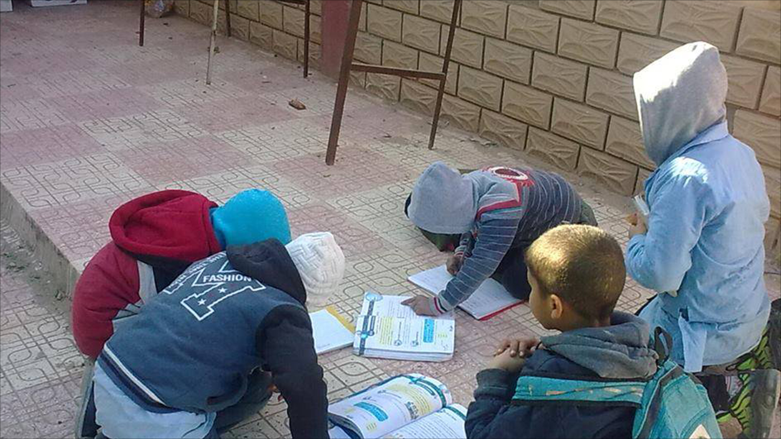 ‪أطفال يطالعون كتبا مدرسية بالجزائر‬ (الجزيرة)