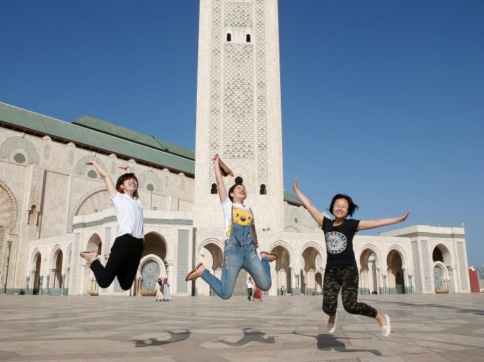 Chinese tourists jump as they pose for photographs at the esplanade of the Hassan II Mosque in Casablanca, October 6, 2016. REUTERS/Youssef Boudlal