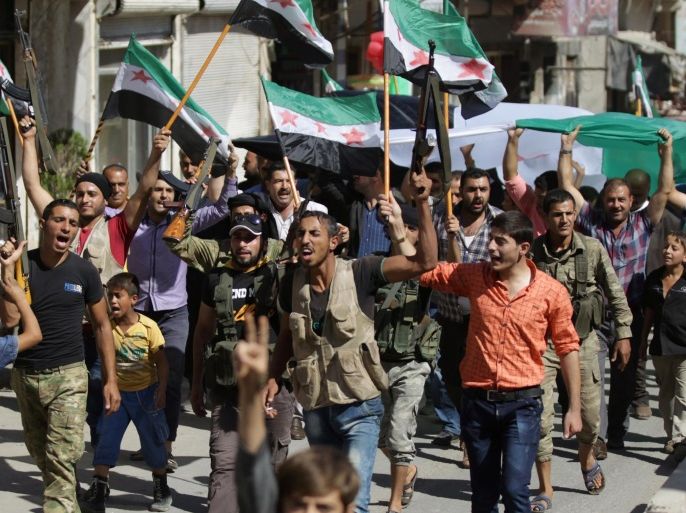 Rebel fighters and civilians carry opposition flags and chant slogans as they take part in a protest to express solidarity with the Free Syrian Army and the people of Aleppo, in the Syrian town of Azaz, September 27, 2016. REUTERS/Khalil Ashawi
