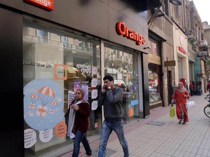 An Egyptian talk on his phone while walking by the newly rebranded 'Orange' store, Cairo, Egypt, 22 March 2016. Orange Egypt is formerly known as Mobinil, one of three telecommunication companies in Egypt and is host of 33.5 million mobile user. Mobinil has been acquired by by the french telecommunication company Orange in 2015 and was fully rebranded starting March this year.