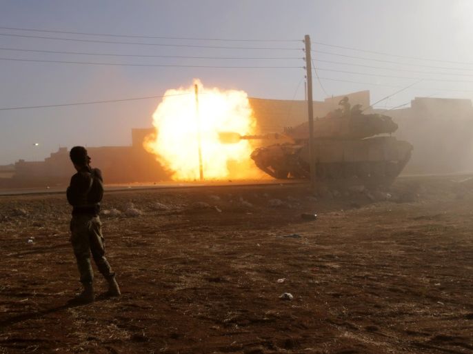 A rebel fighter stands near a Turkish tank as it fires towards Guzhe village, northern Aleppo countryside, Syria October 17, 2016. REUTERS/Khalil Ashawi TPX IMAGES OF THE DAY