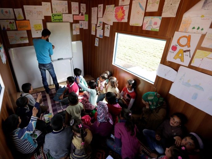 A volunteer teacher teaches inside a mobile educational caravan for children who do not have access to schools on the outskirts of the Syrian rebel-held town of Saraqib, Idlib province March 10, 2016. The group "Saraqib Youth Gathering" created a mobile learning caravan to reach children who have no access to schools in the area. REUTERS/Khalil Ashawi SEARCH "SYRIA SCHOOLS" FOR THIS STORY. SEARCH "THE WIDER IMAGE" FOR ALL STORIES