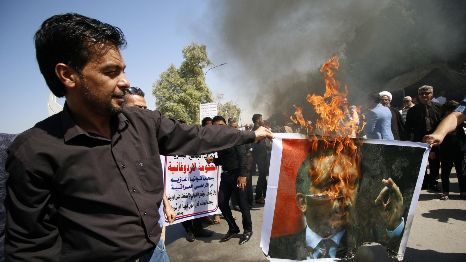 ‪أنصار الحكومة العراقية في البصرة أحرقوا صور الرئيس التركي‬ (رويترز)