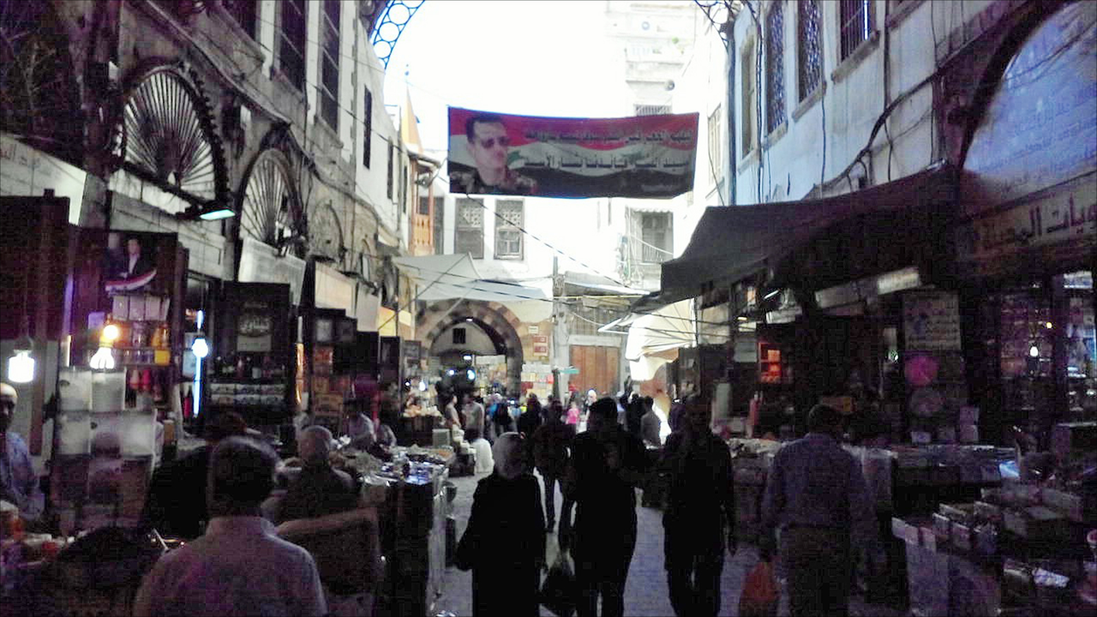 ‪إحدى الأسواق في دمشق حيث صورة للأسد تعلو المحال‬ (الجزيرة)