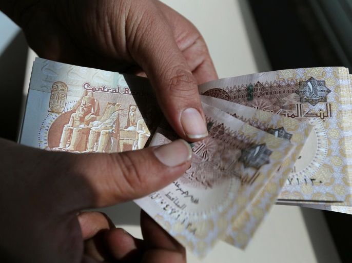 A man counts Egyptian notes outside bank in Cairo, Egypt October 24, 2016. Picture taken October 24, 2016. REUTERS/Mohamed Abd El Ghany