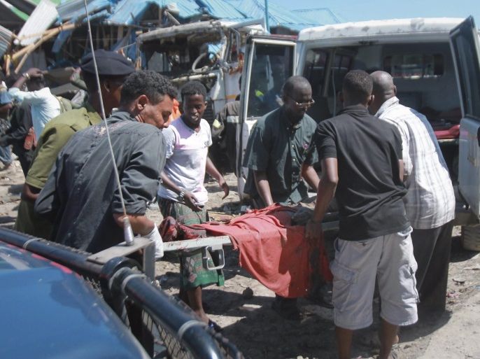 People carry the body of a deceased on a stretcher out of the scene of a car bomb attack at a busy market in the capital Mogadishu, Somalia, 26 November 2016. A car carrying explosives was detonated next to a police checkpoint adjacent to the market on 26 November, killing at least 10 people and injuring many others. No one has claimed responsibility for the attack but the country's Islamit militant group al-Shabab often carries out similar attacks in Mogadishu.