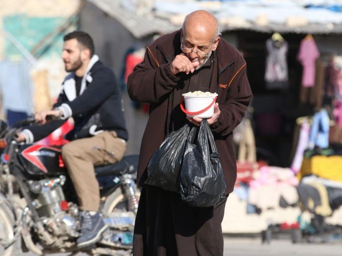 A man eats food that was distributed as aid in a rebel-held besieged area in Aleppo, Syria November 6, 2016. REUTERS/Abdalrhman Ismail