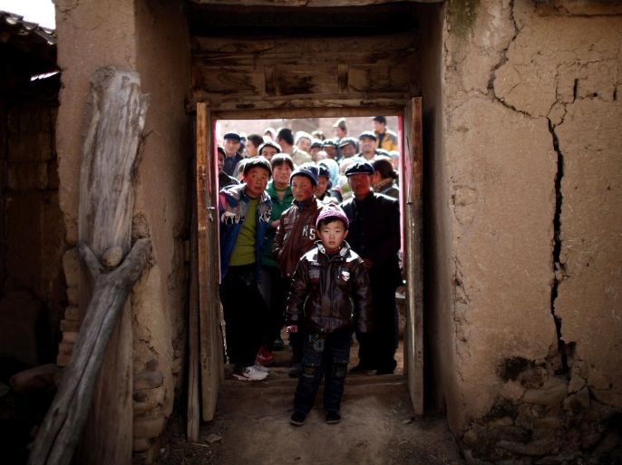 Villagers gather outside a house in Yuangudui, Gansu Province February 12, 2013. Communist Party chief Xi Jinping, who takes over as China's new president during the annual meeting of the legislature beginning on March 5, visited Yuangudui in February to highlight the poverty that still reigns in huge swaths of the country. Closing a yawning income gap is likely to be one of the policy priorities of his administration and the impoverished villagers are fully conscious