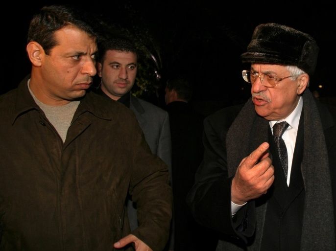 Palestinian President Mahmoud Abbas (R) and his then aide Mohammad Dahlan, walk out Abbas' house in Gaza in this February 11, 2005 file photo. Rumblings in Ramallah in recent weeks have raised expectations that Palestinian politics is in play, with 80-year-old Abbas, in power for more than a decade, facing a mounting challenge to his leadership. Then, in a separate but related development, a Palestinian appeals court ruled that Mohammed Dahlan, a former official in the