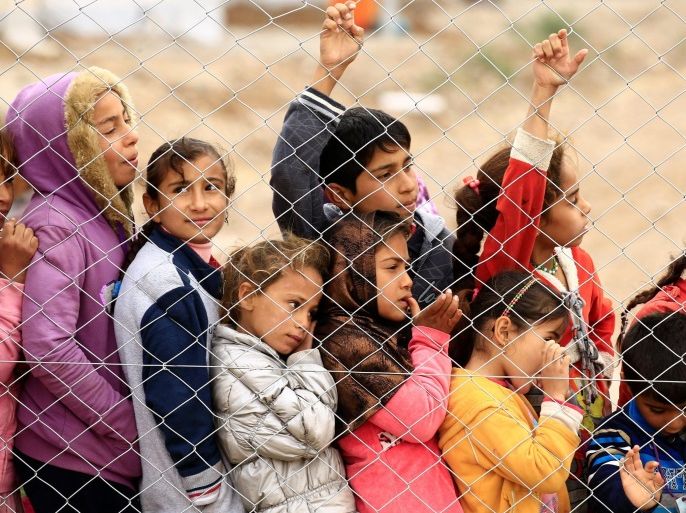 Displaced Iraqi children, who fled the Islamic State stronghold of Mosul, stand at a fence at Debaga camp for the displaced on the outskirts of Erbil, Iraq, December 1, 2016. REUTERS/Thaier Al-Sudani