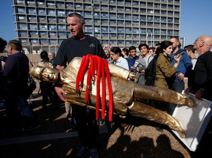 People carry a statue of Israeli Prime Minister Benjamin Netanyahu, which was created by Israeli sculptor Itay Zalait as a political protest against Netanyahu, as it is taken away by the artist from a square outside Tel Aviv's city hall, Israel December 6, 2016. REUTERS/Baz Ratner