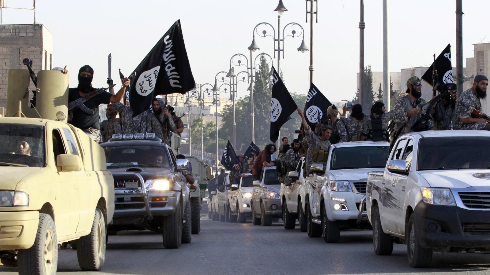 ‪قافلة لمقاتلي تنظيم الدولة الإسلامية أثناء استعراض في شوارع الرقة بسوريا منتصف 2014‬  (رويترز)