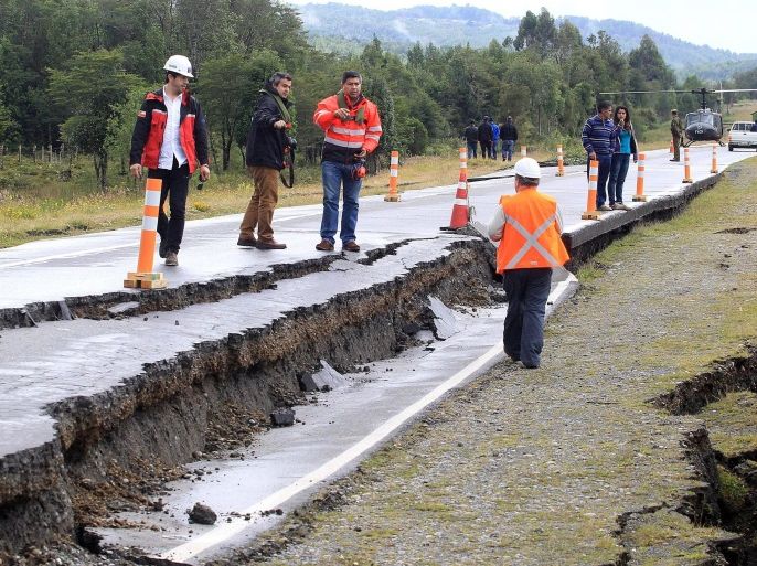 Workers inspect a section of a road that was severely damaged by a 7.6 magnitude earthquake in Tarahuin, on the island of Chiloe, a town 1,250 km south of Santiago, Chile, 25 December 2016. Chilean authorities issued a tsunami warning and ordered the evacuation of coastal areas in five regions of the country following the 7.6 magnitude earthquake that struck 67 kilometers northwest of Melinka, in the region of Aysen, 2,053 kilometers south of Santiago. According to loca